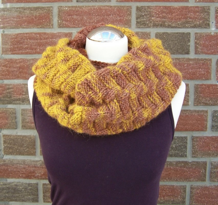 Gestrickter Loop-Schal in Senf und Braun auf Schaufensterpuppe