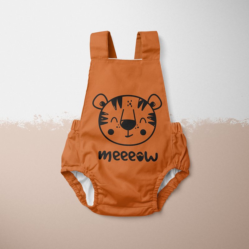 Orangefarbener Baby-Overall mit schwarzem, freundlichem Tigergesicht und dem Schriftzug ‚meeeow‘, flach auf hellem Untergrund präsentiert.