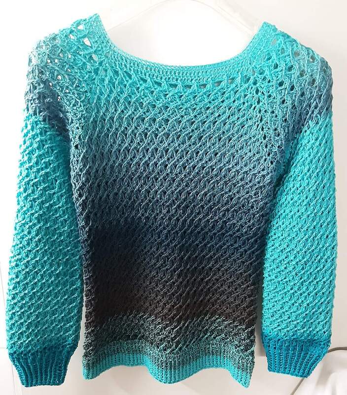 Gehäkelter Damenpullover in Türkis-Blau-Braun mit offenem Netzmuster an einem Bügel