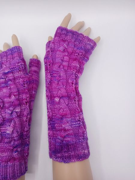 Fingerlose Armstulpen in Pink-Violett mit Zopfmuster an ausgestellten Armen
