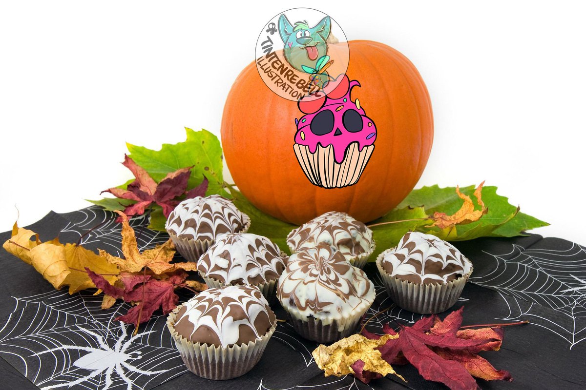 Pumpkin with skull-cupcake sticker beside marbled chocolate cupcakes on spiderweb napkins with scattered fall leaves