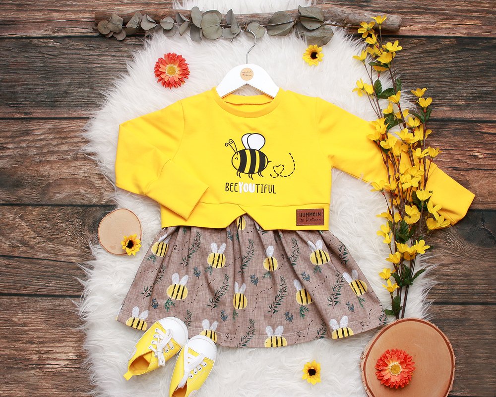 Gelbes Kinderoberteil mit gezeichneter Biene und Rock im Bienenmuster