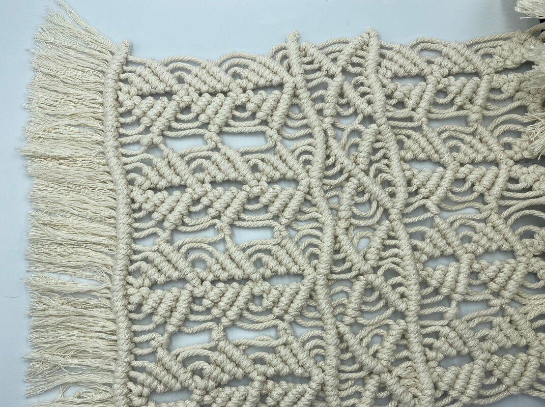 Detailaufnahme cremefarbenes Makramee mit Knotenmuster und Fransen