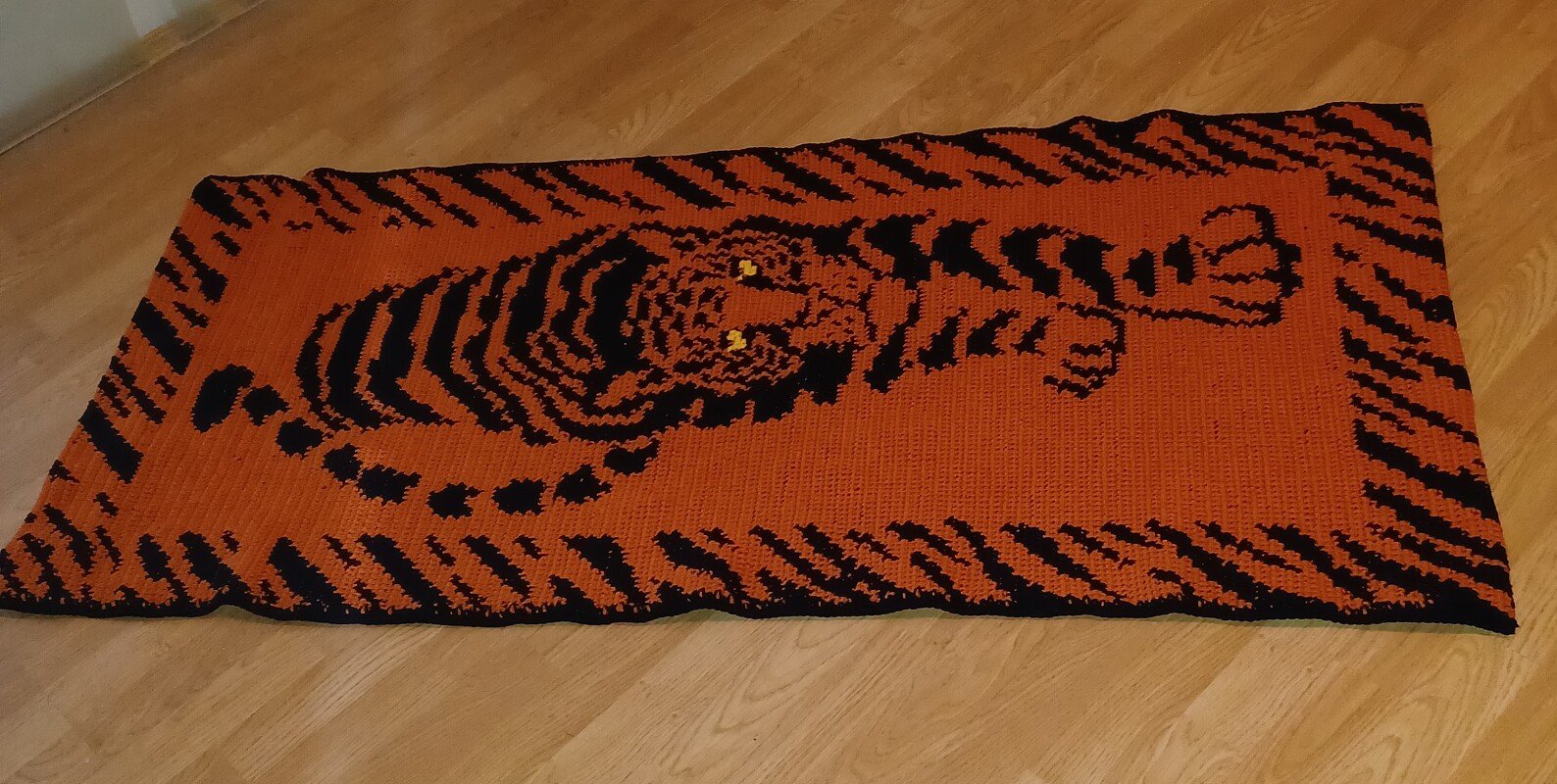 Gehäkelte rechteckige Decke mit schwarzem Tiger-Motiv auf orangefarbenem Grund