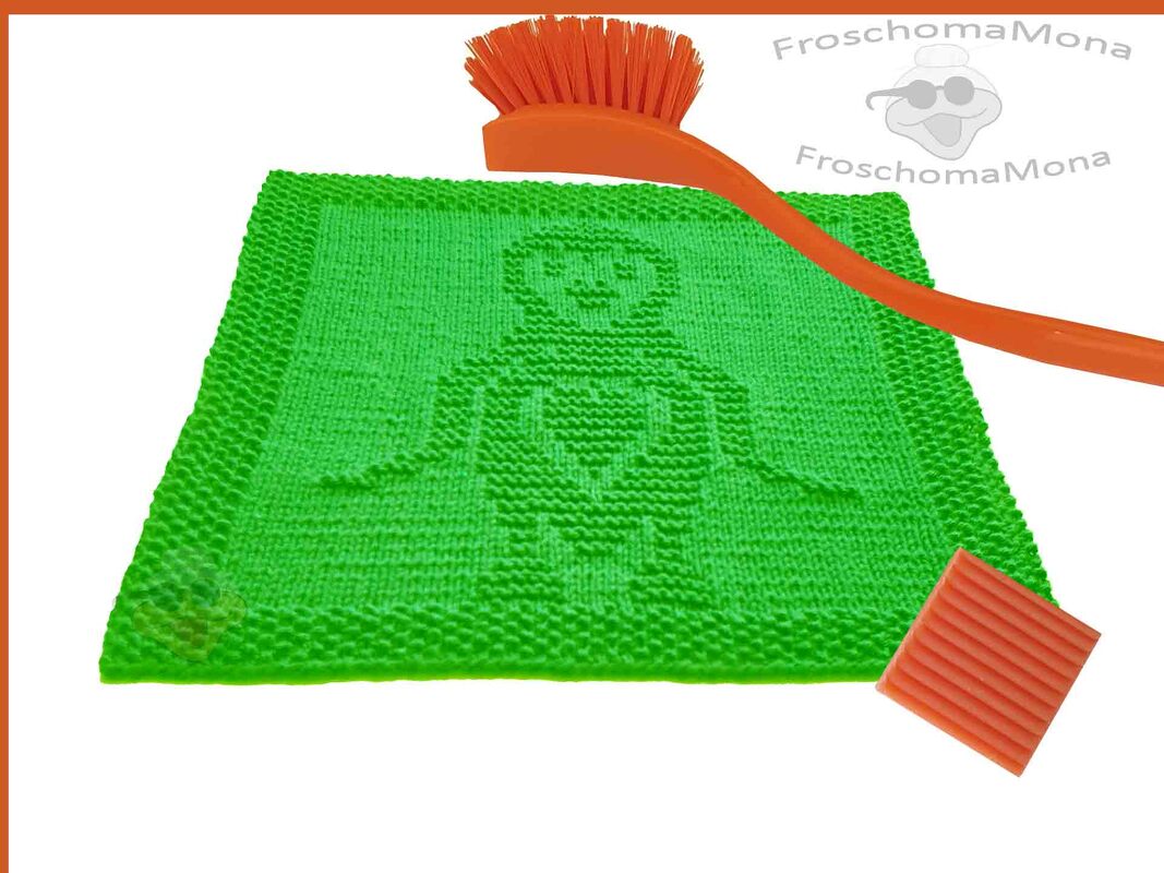 Quadratisches grünes gestricktes Spültuch mit eingestrickter Personenfigur und Herzmotiv, dazu orangefarbene Bürste und Schwamm