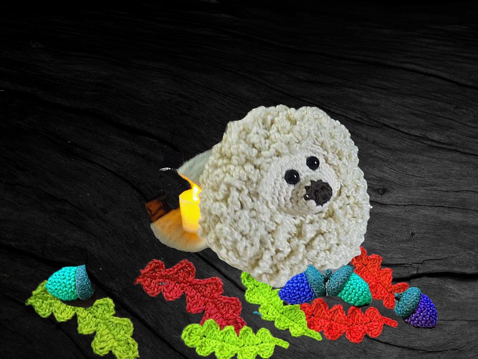 Schäfchenähnliches cremefarbenes Amigurumi mit bunten Häkelakzenten