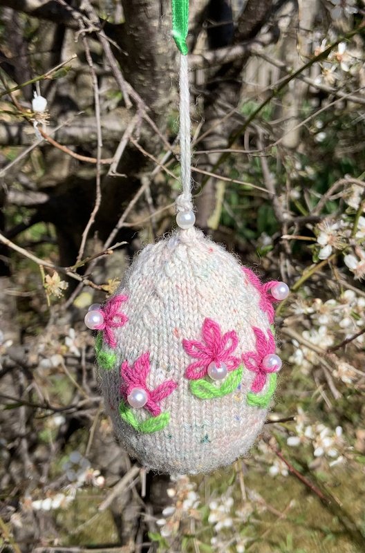 Gestricktes Osterei mit aufgestickten Blümchen