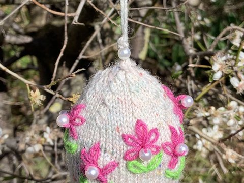 Gestricktes Osterei mit aufgestickten Blümchen