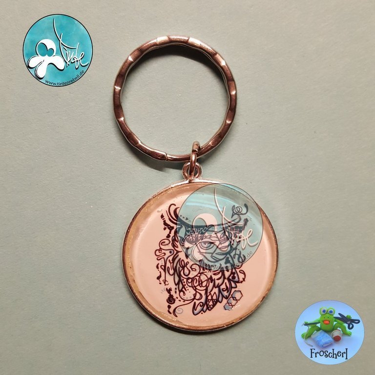 Glossy round keychain pendant with ornate owl line-art on pale pink background and metal split ring