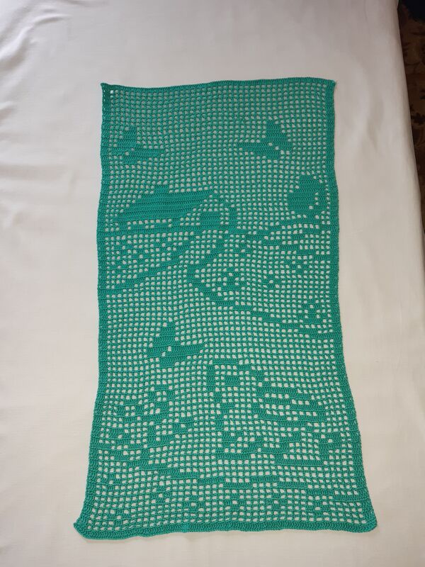 Türkisfarbener gehäkelter Tischläufer im Filetmuster mit Flugzeugmotiven auf hellem Untergrund