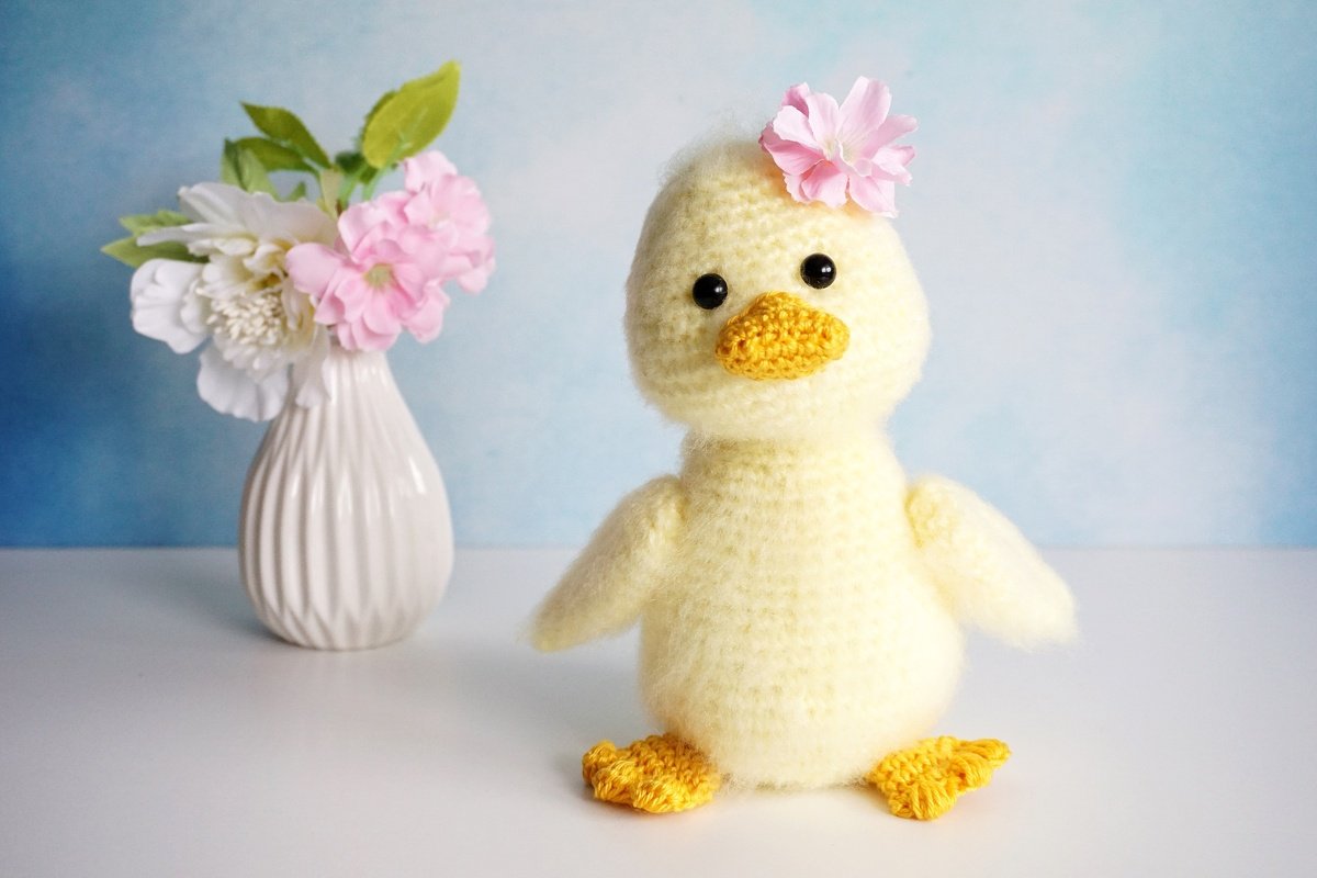 Gelbes Amigurumi-Entchen mit geformtem Schnabel und gelben F
00FC
00DFen, frontal stehend