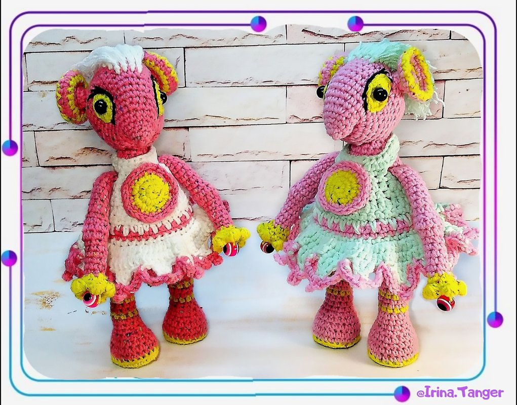 Two crocheted amigurumi dolls in pink and mint ruffled skirts with yellow eye accents, standing side by side