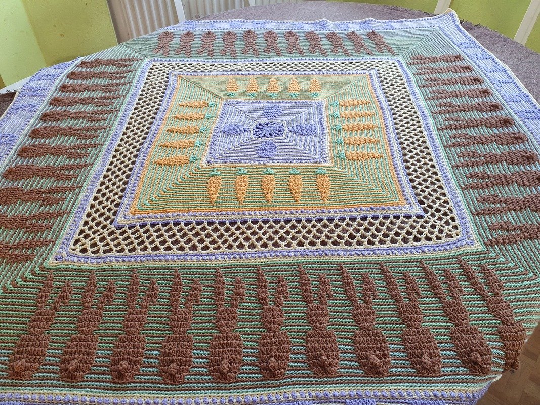 Quadratisches gehäkeltes Deckchen in Pastellgrün, Braun und Flieder mit Karotten- und Hasenmotiven und Netzbordüre