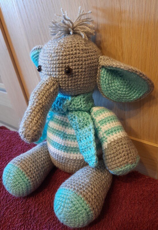 Gehäkelter Amigurumi-Elefant grau mit mint-weiß gestreiftem Bauch und Schal