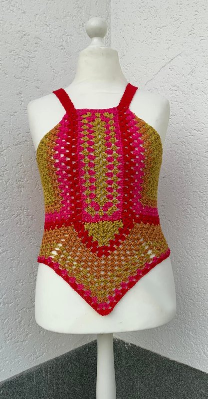 Gehäkeltes Damen-Trägertop mit spitzem Saum in Gelb, Pink und Rot auf Schaufensterpuppe