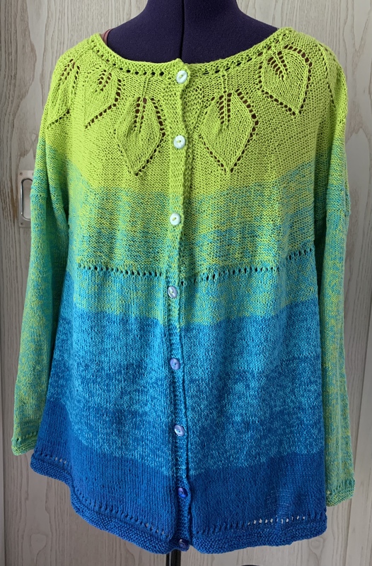 Knöpfbare Damenstrickjacke mit Blatt-Ajour-Passe und grün-blauem Farbverlauf
