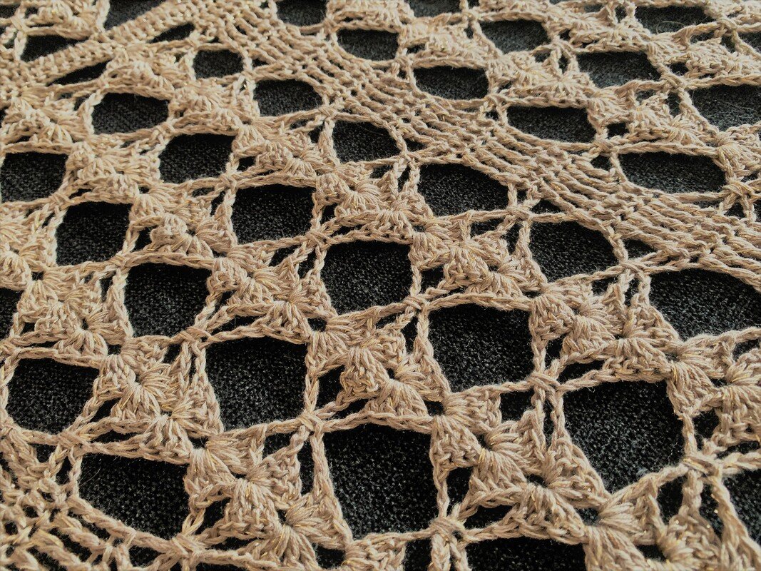 Beige openwork crochet with repeating square motifs for a rectangular shawl
