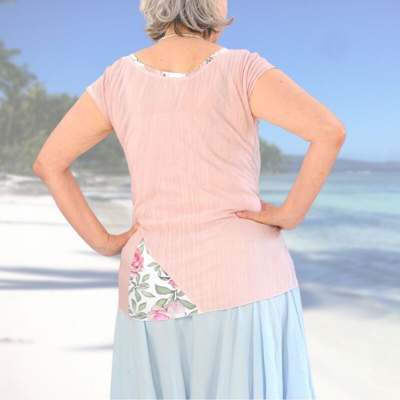 Rückenansicht: pastellrosa Kurzarm-Tunika mit diagonalem floralem Rückeneinsatz