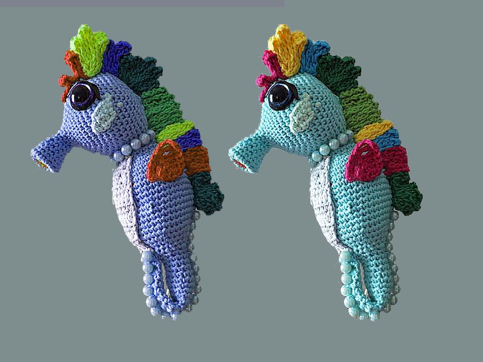 Zwei gehäkelte Seepferdchen Amigurumi in Blau- und Türkistönen mit buntem Kamm und Perlen