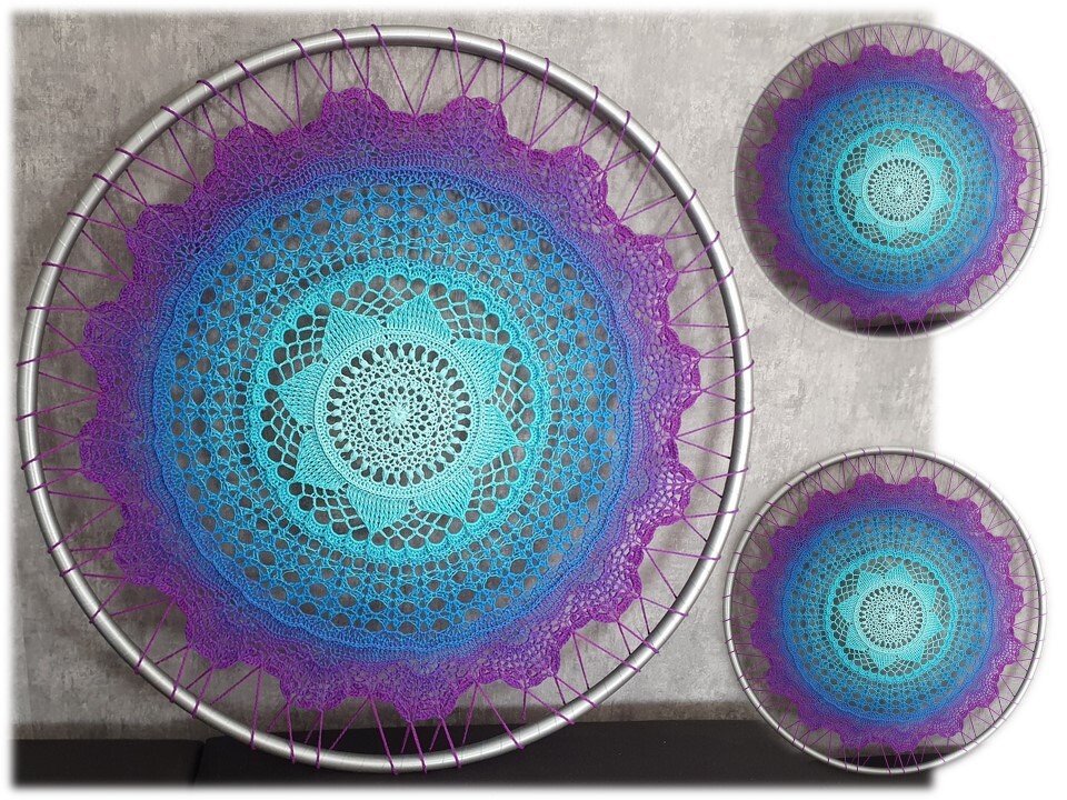 Großes gehäkeltes Mandala in Türkis, Blau und Lila in einem Metallring, dazu zwei kleinere Mandalas