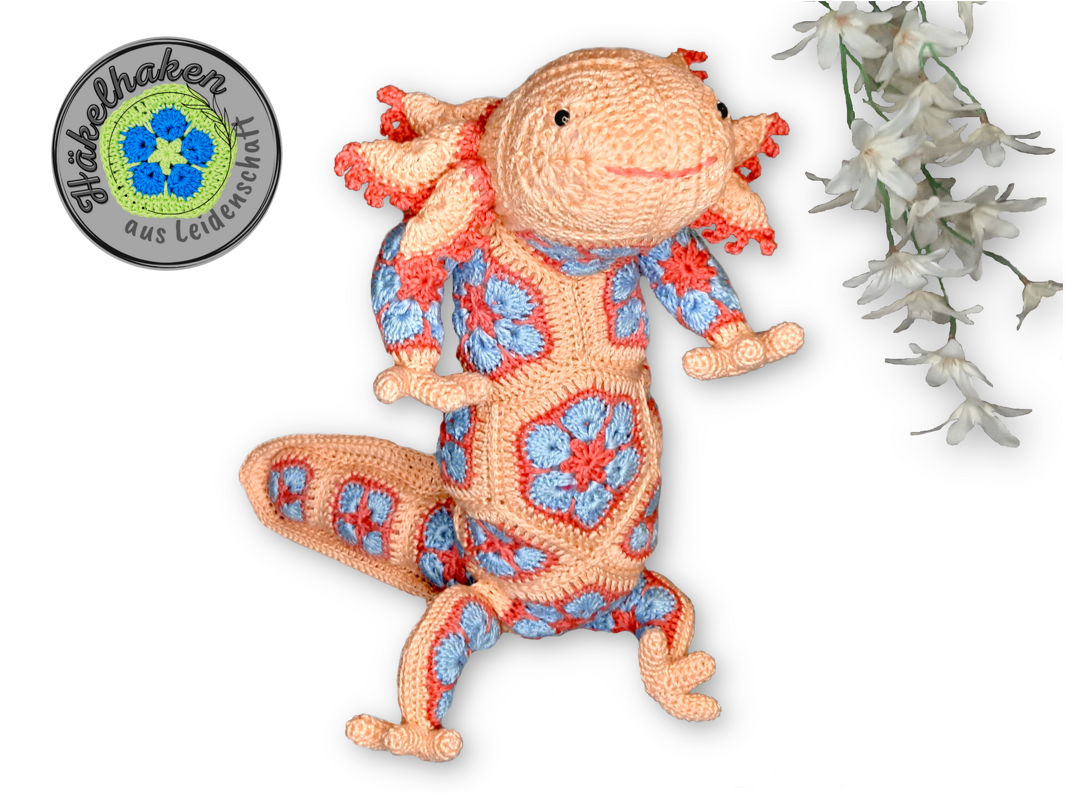 Crocheted axolotl amigurumi made from peach and blue African flower granny motifs, laid flat with visible limbs and tail