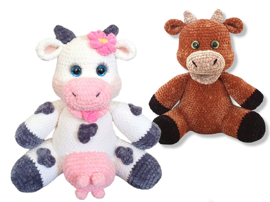 Zwei gehäkelte Amigurumi-Tiere: weiße Kuh mit rosa Blüte und brauner Stier