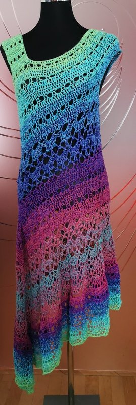 Ärmellose gehäkelte Tunika auf Schneiderpuppe, Farbverlauf von Grün über Blau, Violett bis Pink, Ajourmuster und geschwungener Saum