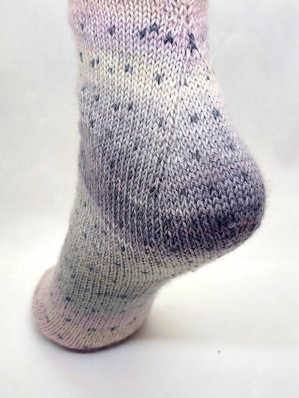 Detailansicht der Ferse einer pastellfarbenen, glatt rechts gestrickten Socke