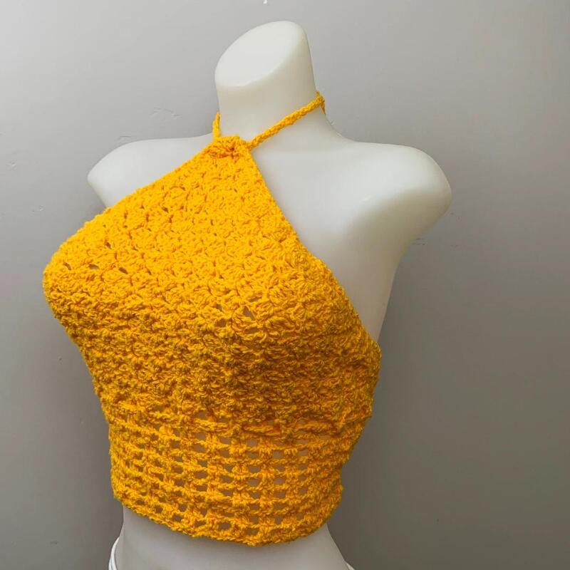 Yellow crochet halter top with textured bodice and openwork midriff on a white mannequin