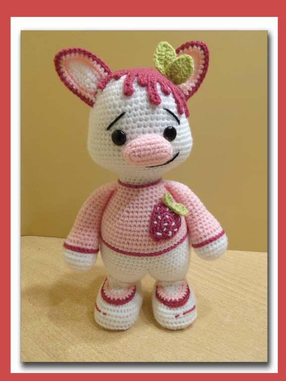 Gehäkelte Amigurumi-Figur rosa-weiß mit Erdbeer-Applikation