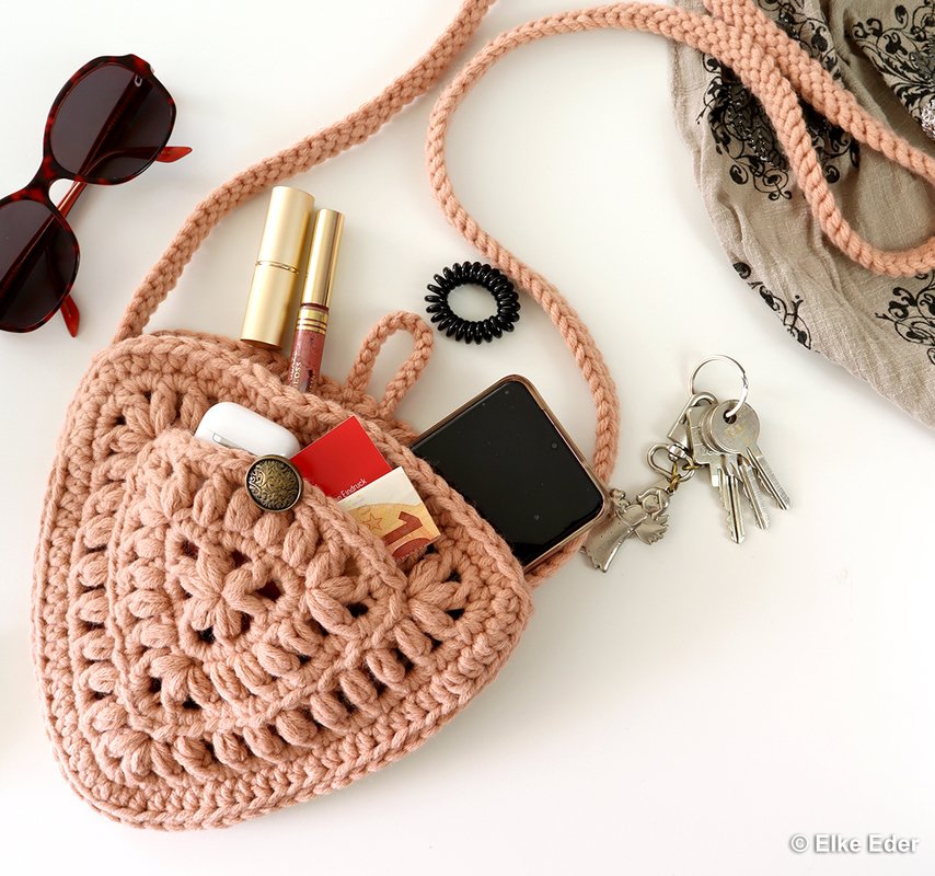 Herzförmige rosa gehäkelte Umhängetasche mit Knopf, Smartphone und Schlüsseln