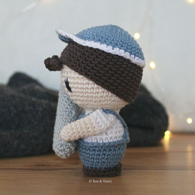 Gehäkelte Amigurumi-Puppe (Junge) mit blauer Mütze und blauer Latzhose, Seitenansicht
