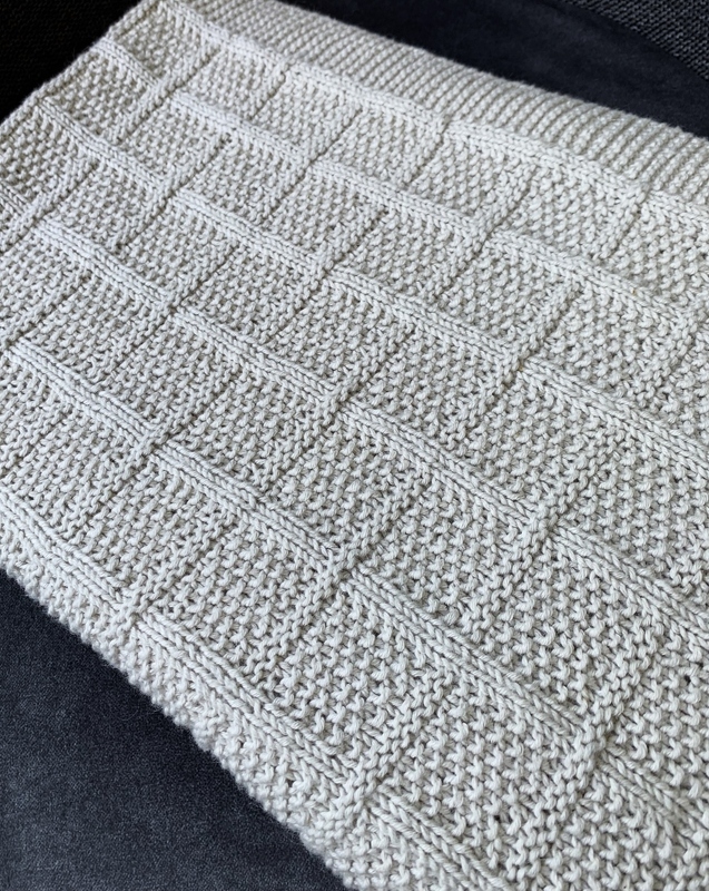 Gestrickte hellbeige Babydecke mit erhabenem Quadratmuster