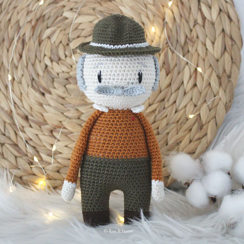 Gehäkelte Amigurumi-Puppe eines älteren Mannes mit Hut, Schnurrbart und Pullover