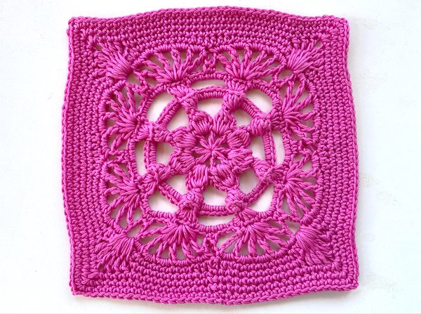 Pinkes gehäkeltes Quadrat mit offenem Blumenmuster