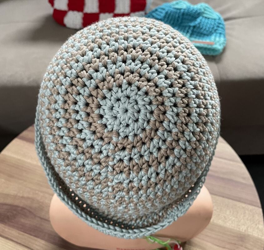 Gehäkelte Damenmütze in Hellblau und Beige auf Kopfmodell