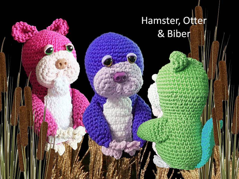 Drei gehäkelte Amigurumi-Tiere (Hamster, Otter, Biber) in Pink, Lila und Grün vor dunklem Hintergrund zwischen Schilfhalmen.