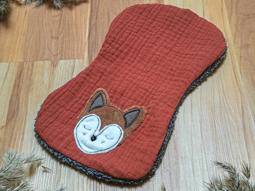 Applikationsstickerei schlafender Fuchs auf rostrotem Baby-Lätzchen mit grauem Fleece-Rücken
