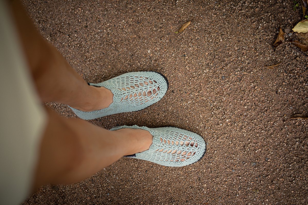 Draufsicht auf hellmintfarbene, gehäkelte Sommerschuhe mit offenem Muster und dunkler Sohle