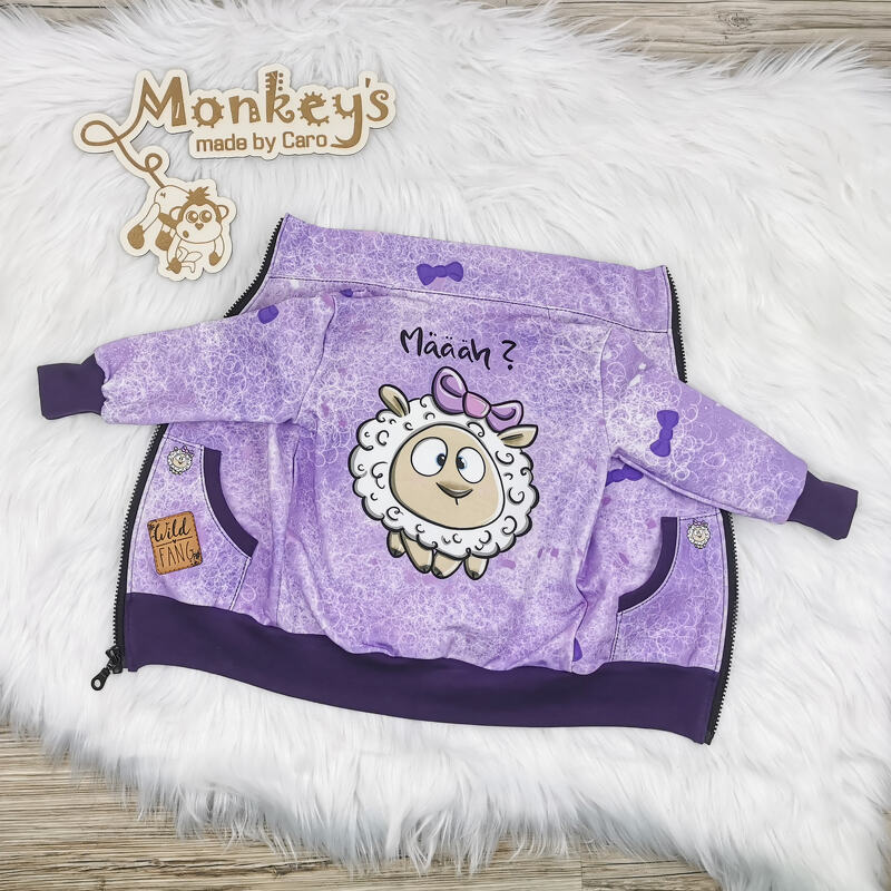 Lila Kinderjacke liegend, Rücken mit Schaf-Aufdruck und Schrift „Määäh?“