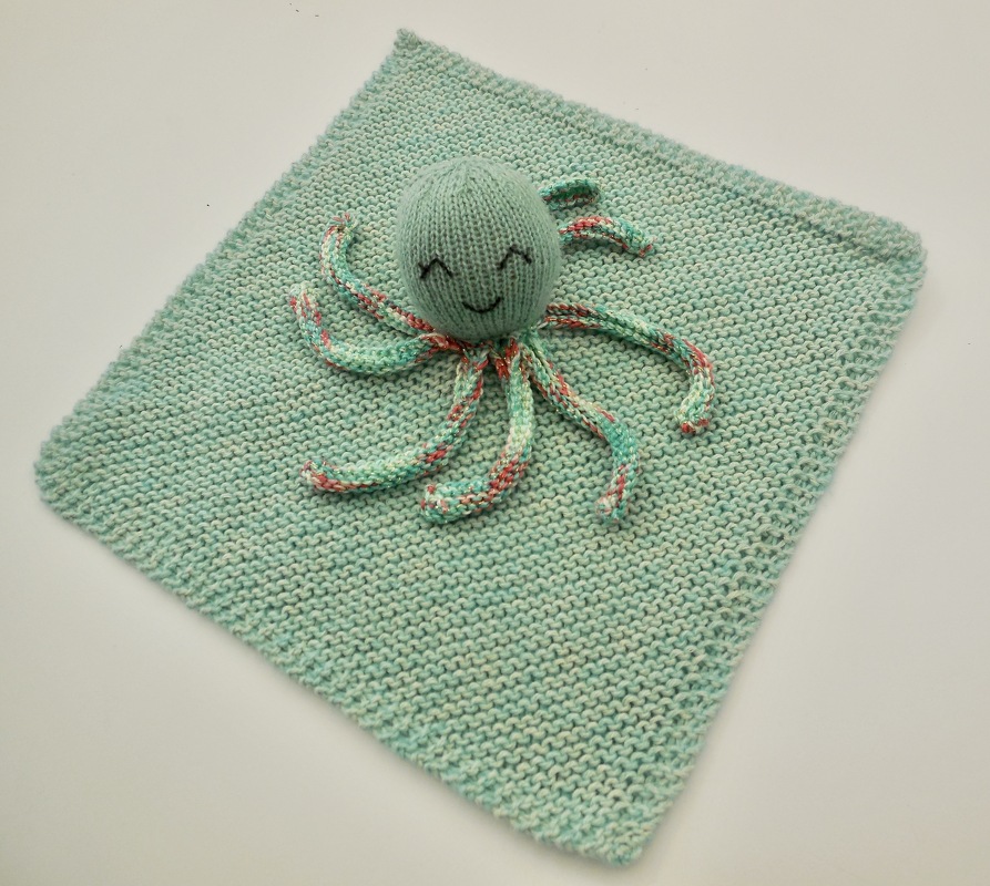 Mintgrünes gestricktes Schmusetuch mit lächelndem Oktopus und mehrfarbigen Tentakeln