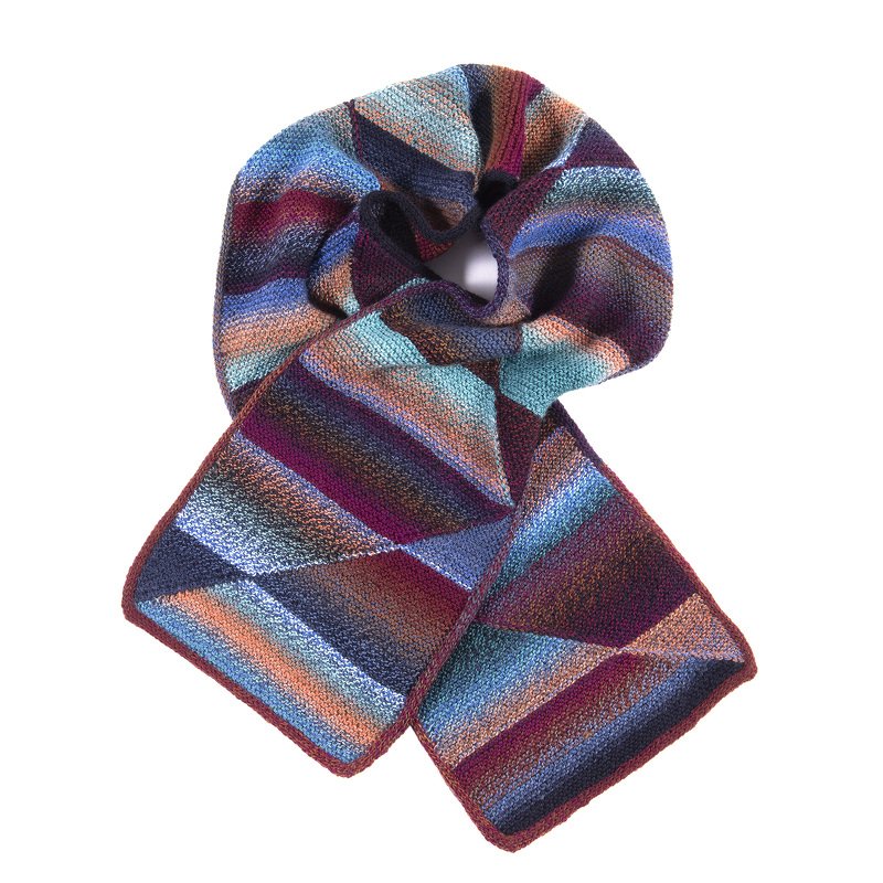 Knitted scarf with multicolored diagonal stripes in blue, teal, orange, red and purple, draped on a white background.
