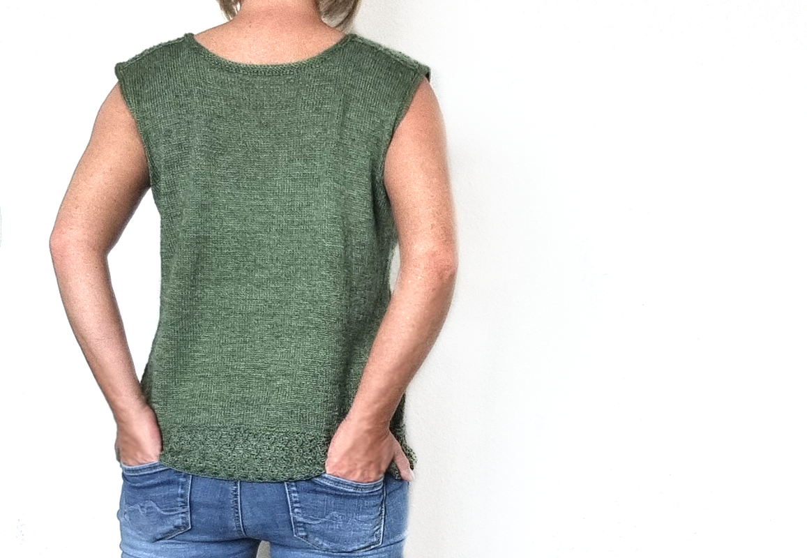 Rückansicht einer Frau in ärmellosem olivgrünem Stricktop und Jeans.