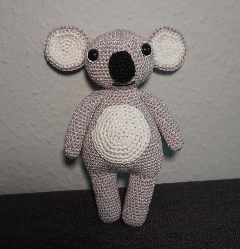Grey crocheted amigurumi koala with white belly and black nose