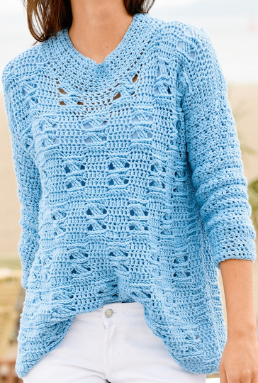 Hellblauer, langer Häkelpulli mit gekreuzten Reliefstäbchen und breiter Ausschnittblende