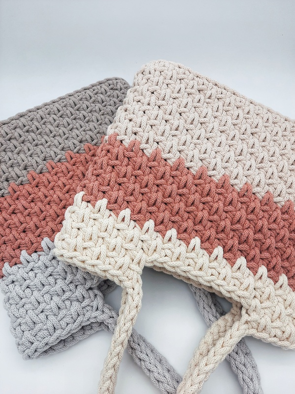 Zwei gehäkelte Shopper in Beige, Terrakotta und Grau mit strukturiertem Muster und geflochtenen Henkeln