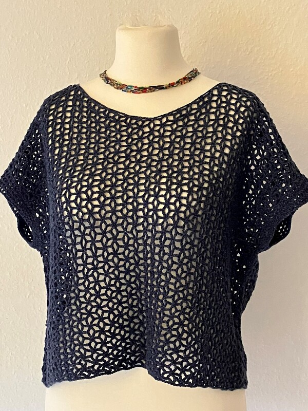 Dunkelblaues gehäkeltes Top mit kurzen Ärmeln und offenem Lochmuster auf weißem Mannequin