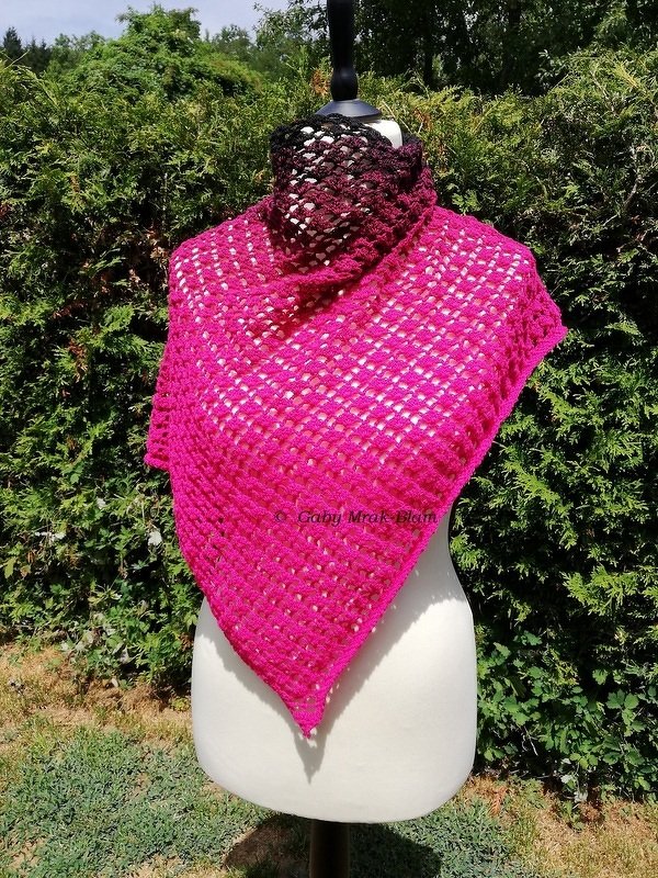 Bright fuchsia open-lace triangle crochet shawl on a mannequin with a dark gradient neck wrap