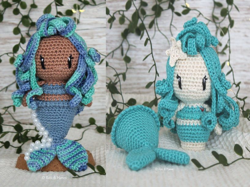 Detailaufnahme von zwei gehäkelten Amigurumi-Meerjungfrauen, eine mit festem Flossenrock, die andere mit abnehmbarer Flosse