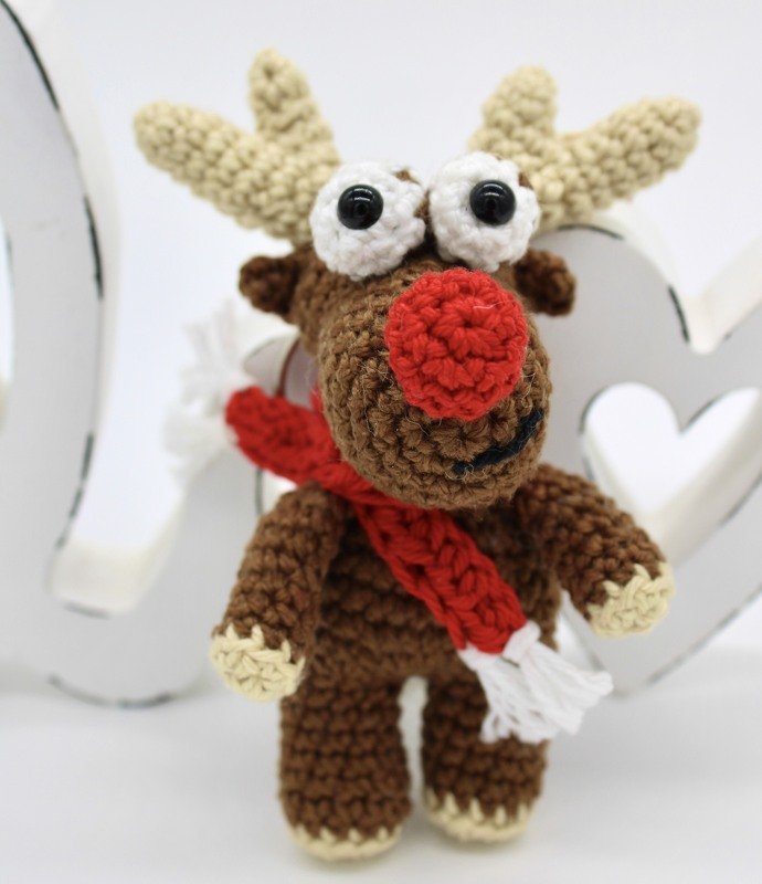 Gehäkeltes braunes Rentier-Amigurumi mit roter Nase und rotem Schal